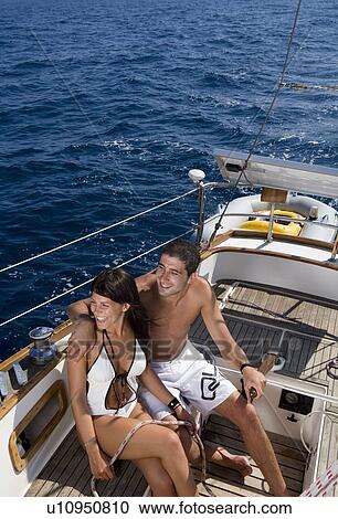 Couple steering a sailboat View Large Photo Image Stock Image - Couple steering a sailboat. Fotosearch