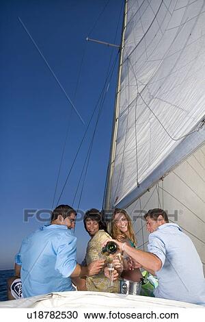 Couples making a toast on sailboat View Large Photo Image Stock Image - Couples making a toast on sailboat. Fotosearch