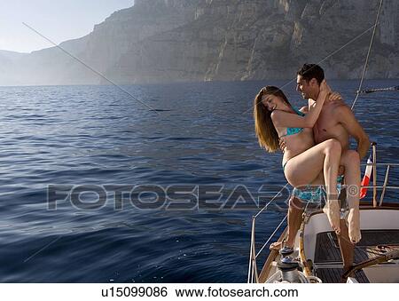 Man lifts girl to sailboats edge View Large Photo Image Stock Photograph - Man lifts girl to sailboats edge. Fotosearch