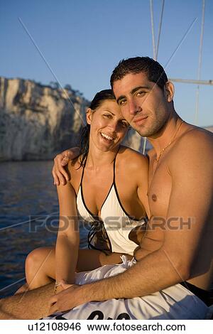 Stock Photograph - Portrait young couple on sailboat. Fotosearch