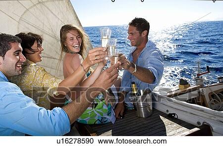 Two couples making a toast on sailboat View Large Photo Image Stock Image - Two couples making a toast on sailboat. Fotosearch