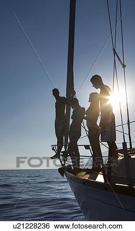 Stock Photograph - Two couples on sailboat sunset. Fotosearch