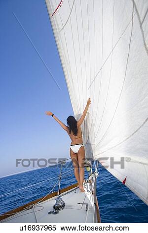 Stock Photography - Woman on sailboat arms open. Fotosearch