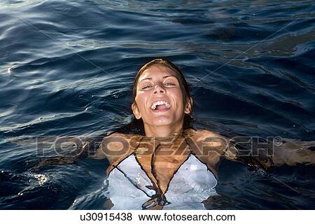 Stock Photo - Young woman in water smiling. Fotosearch