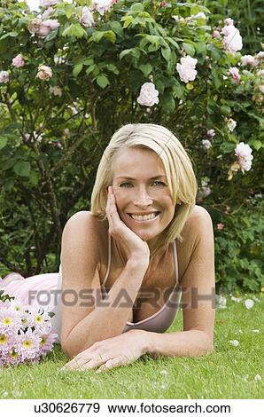 Portrait of smiling woman in garden View Large Photo Image Stock Photo - Portrait of smiling woman in garden. Fotosearch