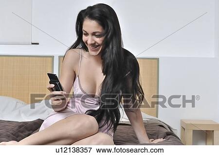 Stock Photo - Woman checking message a her mobile . Fotosearch
