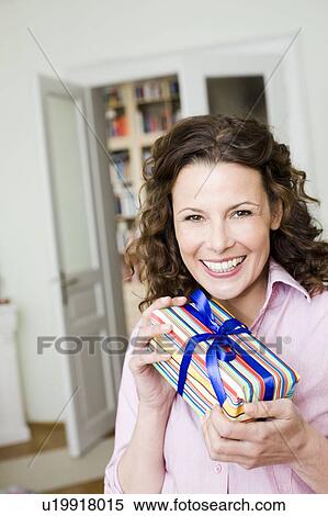Stock Photography - Woman happy about her birthday present. Fotosearch