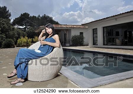 Woman having a drink by the pool View Large Photo Image Stock Image - Woman having a drink by the pool. Fotosearch