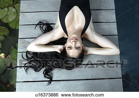 Woman lying down on wooden deck View Large Photo Image Stock Photograph - Woman lying down on wooden deck. Fotosearch