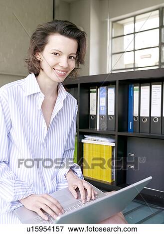Woman on laptop in home office View Large Photo Image Stock Photo - Woman on laptop in home office. Fotosearch