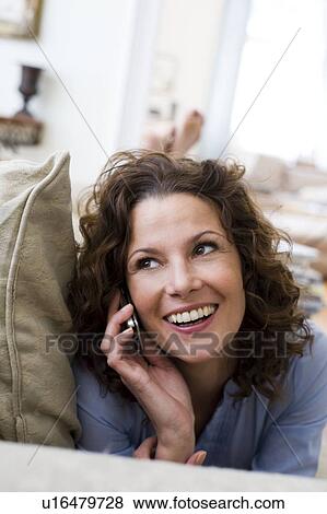 Woman phoning laying on a couch View Large Photo Image Stock Photo - Woman phoning laying on a couch. Fotosearch