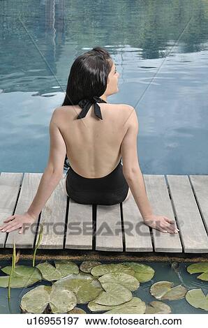 Woman sitting by the swimming pool View Large Photo Image Stock Photo - Woman sitting by the swimming pool. Fotosearch
