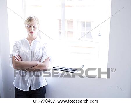 Woman against window looking to camera View Large Photo Image Stock Photo - Woman against window looking to camera. Fotosearch