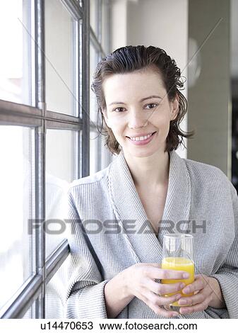 Woman in bathrobe by window drinking View Large Photo Image Stock Image - Woman in bathrobe by window drinking. Fotosearch