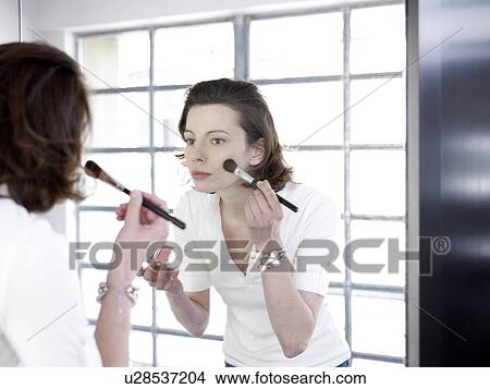 Woman in mirror applying make up View Large Photo Image Picture - Woman in mirror applying make up. Fotosearch