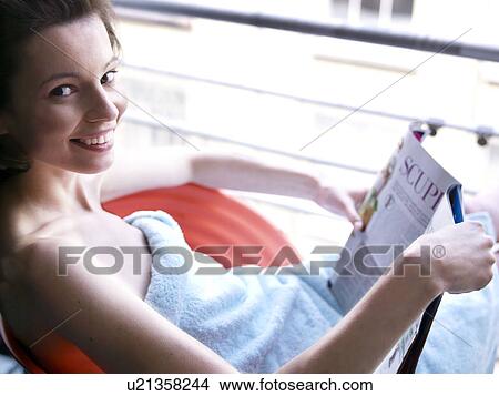 Picture - Woman sitting at window reading. Fotosearch