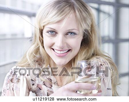 Stock Photo - Woman smiling to camera with wine glass. Fotosearch