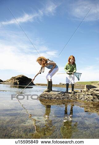 2 girls fishing in rock pool View Large Photo Image Stock Photo - 2 girls fishing in rock pool. Fotosearch