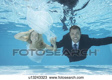 Bride and groom swimming underwater View Large Photo Image Stock Image - Bride and groom swimming underwater. Fotosearch