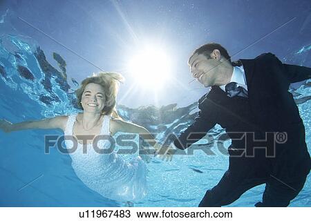 Bride and groom underwater View Large Photo Image Stock Image - Bride and groom underwater. Fotosearch