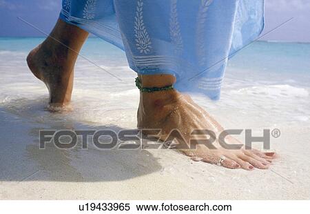 Stock Photography - Close up of feet on beach. Fotosearch