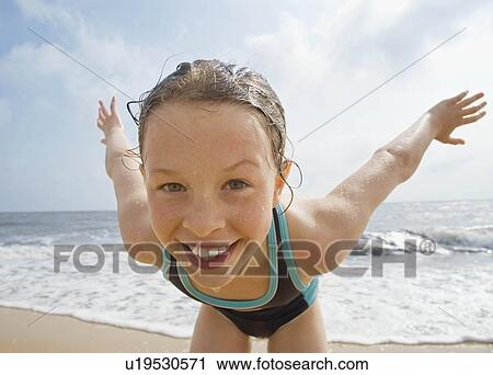 Stock Image - Girl looking to camera with sea behind. Fotosearch