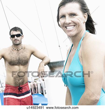 Portrait of a mid adult woman smiling with a mid adult man standing behind her View Large Photo Image Stock Image - Portrait of a mid adult woman smiling with a mid adult man standing behind her. Fotosearch
