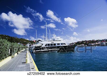 Sailboats moored at a harbor View Large Photo Image Stock Image - Sailboats moored at a harbor. Fotosearch