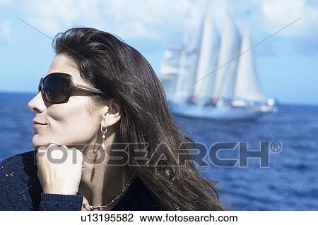 Close-up of a mid adult woman wearing sunglasses View Large Photo Image Stock Image - Close-up of a mid adult woman wearing sunglasses. Fotosearch