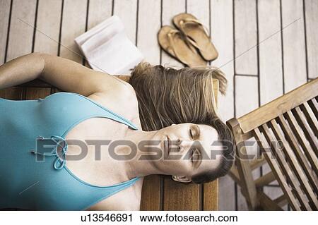 High angle view of a mid adult woman sleeping on a bench View Large Photo Image Stock Image - High angle view of a mid adult woman sleeping on a bench. Fotosearch