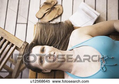 High angle view of a mid adult woman lying on a bench View Large Photo Image Stock Photography - High angle view of a mid adult woman lying on a bench. Fotosearch