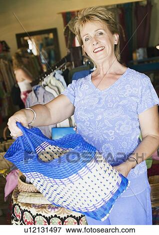 Portrait of a mature woman holding a bag View Large Photo Image Stock Photo - Portrait of a mature woman holding a bag. Fotosearch