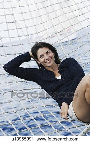 Portrait of a mid adult woman lying in a hammock View Large Photo Image Stock Image - Portrait of a mid adult woman lying in a hammock. Fotosearch