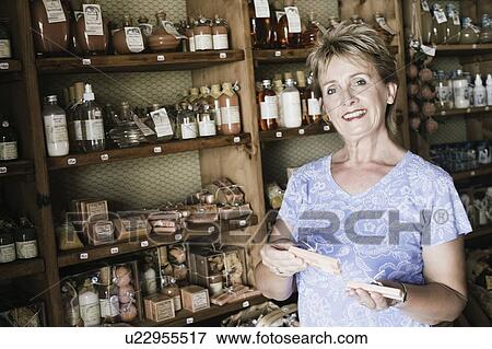 Portrait of a mid holding medicines in a medicine store View Large Photo Image Stock Photo - Portrait of a mid holding medicines in a medicine store. Fotosearch
