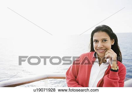 Portrait of a young woman standing on a boat deck and smiling View Large Photo Image Stock Photo - Portrait of a young woman standing on a boat deck and smiling. Fotosearch