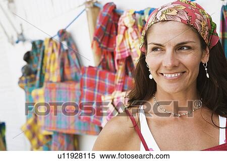 Close-up of a mid adult woman at a market stall and smiling View Large Photo Image Stock Photography - Close-up of a mid adult woman at a market stall and smiling. Fotosearch
