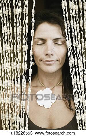 Stock Image - Close-up of a mid adult woman with her eyes closed. Fotosearch
