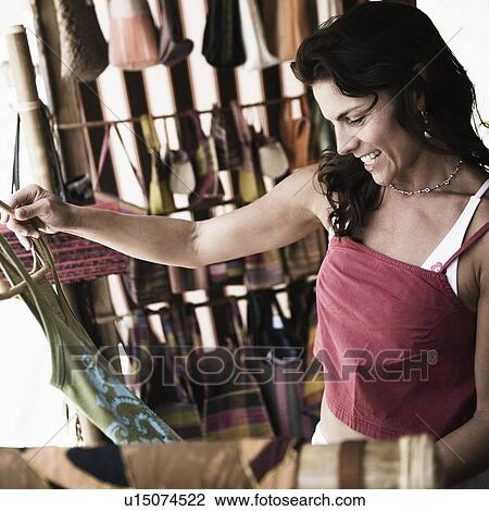 Mid adult woman shopping in a clothing store View Large Photo Image Stock Image - Mid adult woman shopping in a clothing store. Fotosearch