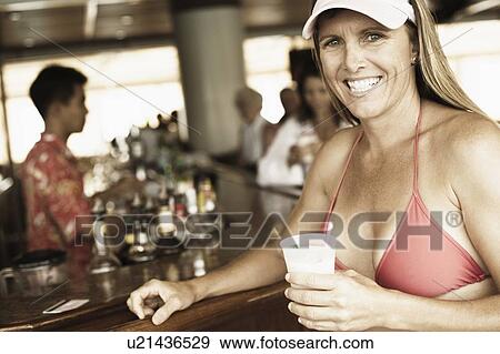 Portrait of a mid adult woman holding a drink View Large Photo Image Stock Photo - Portrait of a mid adult woman holding a drink. Fotosearch