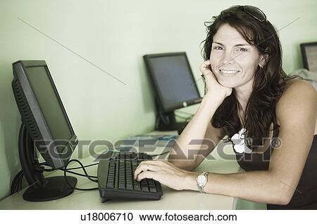 Portrait of a mid adult woman using a computer View Large Photo Image Stock Image - Portrait of a mid adult woman using a computer. Fotosearch
