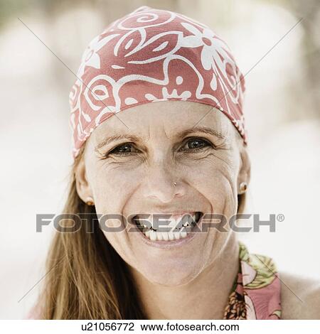 Stock Image - Portrait of a mid adult woman wearing a headscarf and smiling. Fotosearch