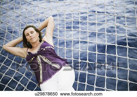 High angle view of a mid adult woman sleeping on the net of a ship View Large Photo Image Stock Image - High angle view of a mid adult woman sleeping on the net of a ship. Fotosearch