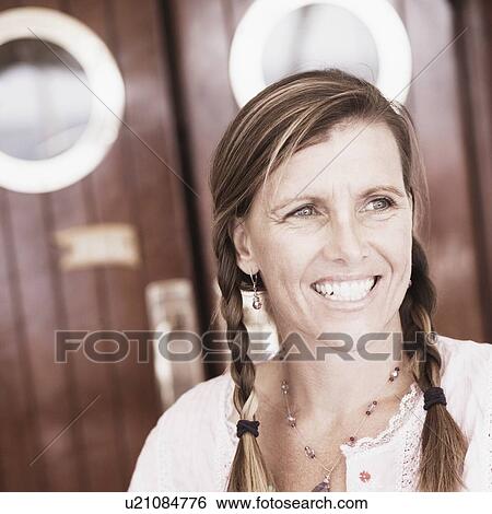 Mid adult woman holding a glass of cocktail and smiling View Large Photo Image Stock Photograph - Mid adult woman holding a glass of cocktail and smiling. Fotosearch