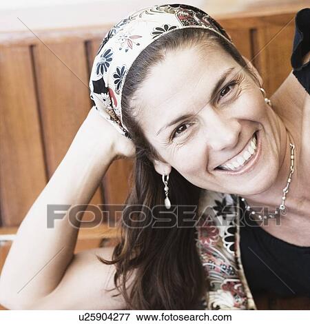 Portrait of a mid adult woman lying on a bench and smiling View Large Photo Image Stock Photo - Portrait of a mid adult woman lying on a bench and smiling. Fotosearch