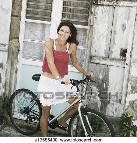 Portrait of a mid adult woman riding a bicycle and smiling View Large Photo Image Stock Photo - Portrait of a mid adult woman riding a bicycle and smiling. Fotosearch