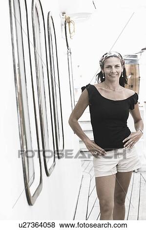 Portrait of a mid adult woman standing with arms akimbo and smiling View Large Photo Image Stock Photo - Portrait of a mid adult woman standing with arms akimbo and smiling. Fotosearch