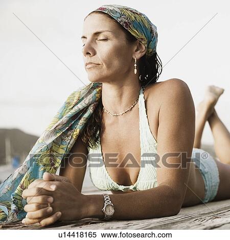 Close-up of a mid adult woman lying on a pier View Large Photo Image Stock Photography - Close-up of a mid adult woman lying on a pier. Fotosearch