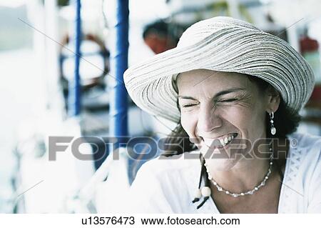 Close-up of a mid adult woman wearing a sunhat and smiling View Large Photo Image Stock Image - Close-up of a mid adult woman wearing a sunhat and smiling. Fotosearch