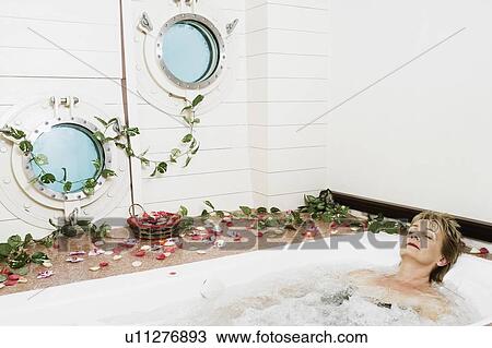 Stock Image - Mature woman in a bathtub. Fotosearch