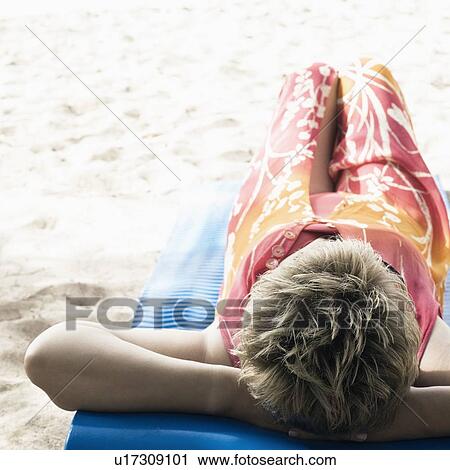 Mature woman lying on a float on the beach View Large Photo Image Stock Image - Mature woman lying on a float on the beach. Fotosearch